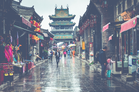 PINGYAO, CHINA - MAY 21, 2018: Tourists and local people in the ancient city of Pingyao in central China, Asia. Rainy weather.のeditorial素材