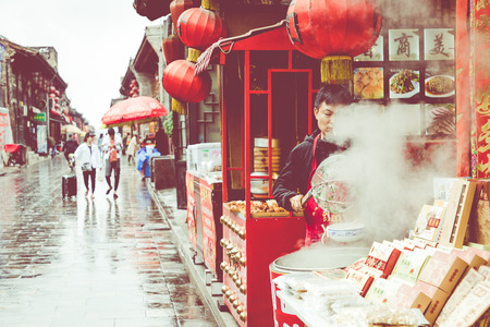 PINGYAO, CHINA - MAY 21, 2018: Tourists and local people in the ancient city of Pingyao in central China, Asia. Rainy weather.のeditorial素材