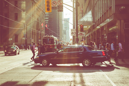 TORONTO, CANADA - SEPTEMBER 17, 2018: Rush hour at Toronto downtown, many people on the street. Sunset time with sun flares.のeditorial素材