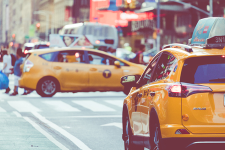 NEW YORK - SEPTEMBER 2, 2018: Yellow cab speeds through Times Square the busy tourist intersection of neon art and commerce and is an iconic street of New York City, USA.のeditorial素材