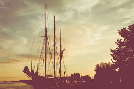 TORONTO, CANADA - SEPTEMBER 18, 2018: Sunset at the Ontario lake with tall ship standing at marina...