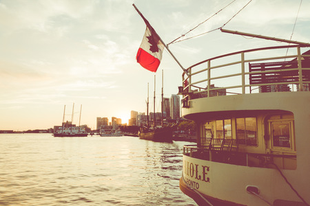 TORONTO, CANADA - SEPTEMBER 18, 2018: Sunset at the Ontario lake with tall ship standing at marina...