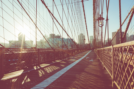 Vintage Color View of Brooklyn Bridge with Detail of Girders and Support Cables, Manhattan City Skyline at Sunrise, New York City, New York, USAの写真素材