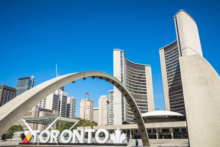 TORONTO, CANADA - SEPTEMBER 17, 2018: View of Toronto Sign on Nathan Phillips Square, in Toronto,  City Hall and the Freedom Arches in background.のeditorial素材