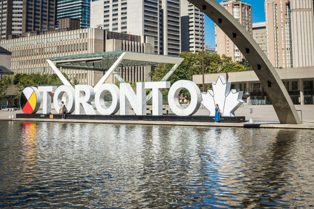 TORONTO, CANADA - SEPTEMBER 17, 2018: View of Toronto Sign on Nathan Phillips Square, in Toronto,  City Hall and the Freedom Arches in background.のeditorial素材