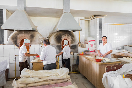 TASHKENT, UZBEKISTAN - AUGUST 22, 2018: Uzbek people baking traditional uzbekistan bread.のeditorial素材