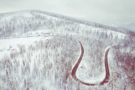 Winter scenery in Silesian Beskids mountains. Top aerial view of snow mountain landscape with trees and road.の写真素材