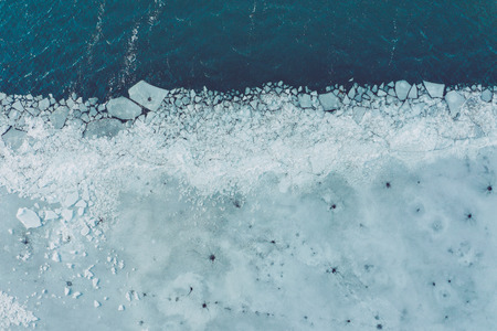 Glacier Lagoon with icebergs from above. Aerial View. Cracked Ice from drone view. Background texture concept.の写真素材