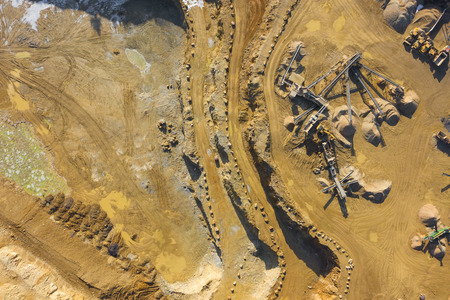 Aerial view of opencast mining quarry with lots of machinery. Industrial place view from above....