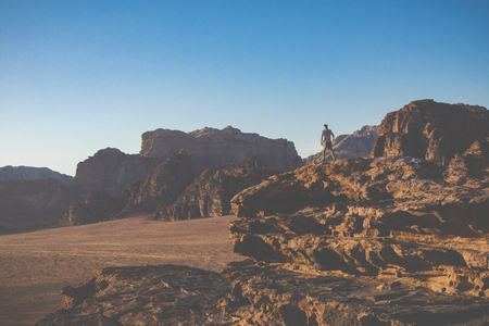 A tourist standing by the look out of a panoramic view of the desert in Wadi Rum, Jordan, Middle...