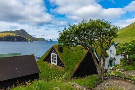 Bour village. Typical grass-roof houses and green mountains. Vagar island, Faroe Islands. Denmark. Europe.の写真素材