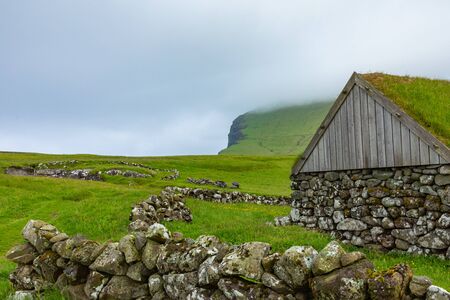 View of fishing village in Koltur island. Faroe Islands. Green roof houses. Nordic natural landscape.の写真素材