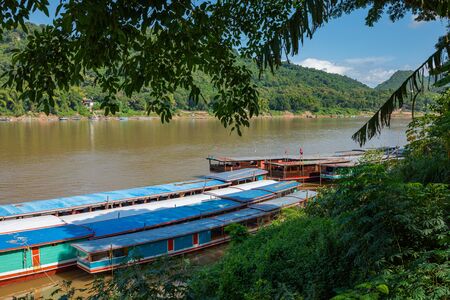 Traditional Long Boat on the Mekong River and mountains view in Luang Prabang, Laos.の写真素材
