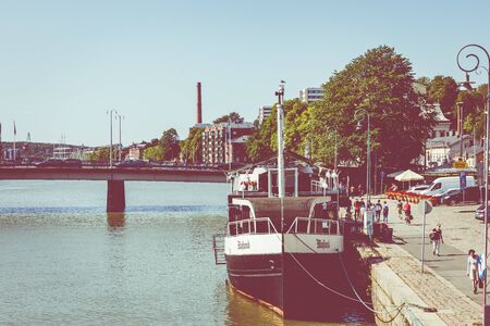 TURKU, FINLAND - AUGUST 02, 2019: View to the Aura river in Turku, Finland. Waterfront and harbour with ships and boats where are bars and restaurants. Turku is one of popular tourist destinations.のeditorial素材