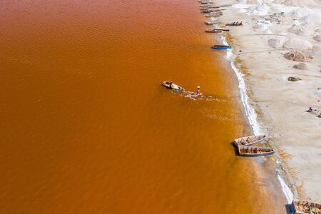 Aerial view of the small boats for salt collecting at pink Lake Retba or Lac Rose in Senegal. Photo...