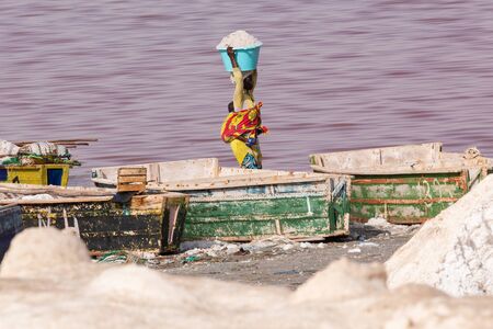 LAC ROSE, SENEGAL - NOVEMBER 13, 2019: People harvesting salt on Lac Rose or Lake Retba. Dakar. West...
