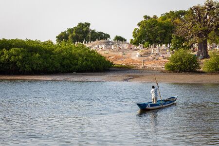 JOAL-FADIOUTH, SENEGAL - NOVEMBER15, 2019: Cemetery at Joal-Fadiouth. Christian graves and crosses next to large baobabs. Fadiauth Island. Senegal. West Africa.のeditorial素材