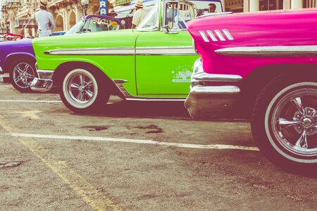 HAVANA, CUBA - DECEMBER 21, 2019: Vintage colored classic american cars front of the Galician Palace...