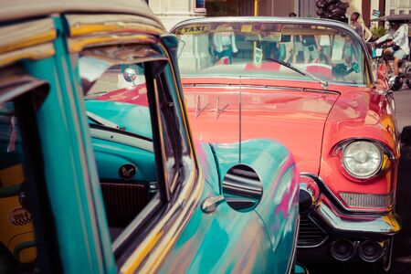 HAVANA, CUBA - DECEMBER 21, 2019: Vintage colored classic american cars front of the Galician Palace on Prado Street in Havana, Cuba.のeditorial素材