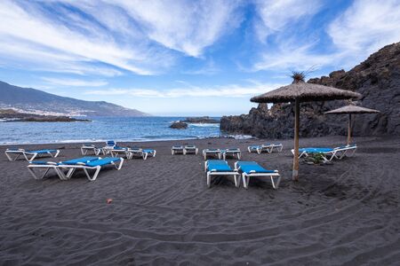 Blue sunbeds and black sand beach at Los Cancajos. La Palma, Canary Island, Spain.の写真素材