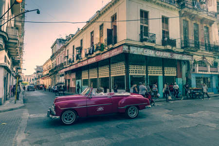 HAVANA, CUBA - DECEMBER 10, 2019: Havana Cuba Classic Cars. Typcal Havana urban scene with colorful buildings and old cars.のeditorial素材