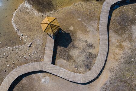 Aerial view of wooden path over turquiose lake colour. Drought. Drone top view.