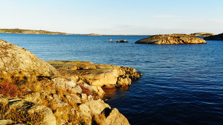 Rocky coast, in the distance you can see the rock of the island, on the fjord. North Sea Coast. Norwegian autumn. Telemark region of Norwayの写真素材