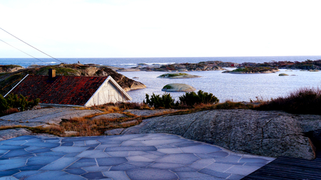 Brick terrace with stone slabs, situated on the rocks. The view from the terrace above the rooftops on a small island shelf. North Sea Coast. Norwegian winter. Telemark region of Ostlandet. Eastern Norway.の写真素材