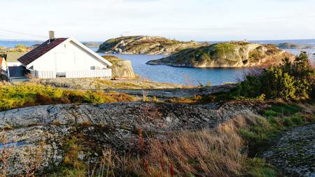 A small wooden cabin on the rocks, small island shelf. North Sea Coast. Norwegian winter. Telemark region of Ostlandet. Eastern Norway.の写真素材