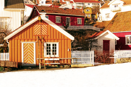 Kragero, Telemark. Norway - February 2015. Colorful old traditional buildings. Wooden houses, summer buildings in the small port on the gulf. Winter, snow on the street. Sunny Day.のeditorial素材