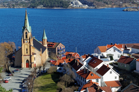 Kragero, telemark. Norway - February 2015. Old brick church, tall towers, the clock on the church...