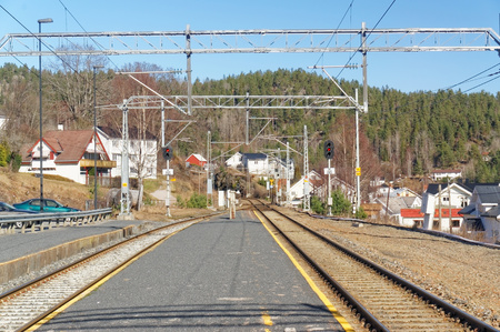 Drangedal, Norway, March 21, 2015: Railway Tracks and asphalt railway platform in a small town.. Early spring.のeditorial素材