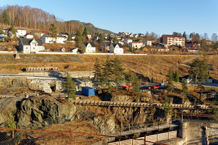 Notodden, Norway, March 21, 2015:Old concrete built on a hydroelectric dam on the river bank Tinnelva in Notodden. Wooden channel for floating plant trees Tinfos. Early spring. Early spring.のeditorial素材
