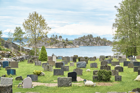 OSPEVIKA, NORWAY - May 25, 2015
Norwegian cemetery early spring. Old crosses covered with rust. Granite plates. Around the rocks. A view of the fjord. The cemetery opened in 1865. Region Norway - Telemark, village Kragero.のeditorial素材