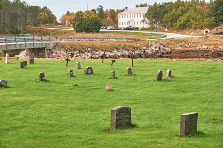 Svellingen, Norway - October 2, 2016: Rural cemetery in autumn in Norway island. Around the rocks covered with mosses and lichens. Near the fjord. October colors. Islands region in the province of Trondelag.のeditorial素材