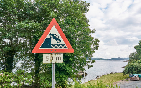 Fjord view. Road sign warning before sinking car. Norwegian fjords Bokna Fjord landscape located in Rogaland county. Around Stavanger. Small island Fogn. Windy day.の写真素材