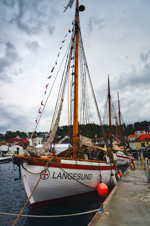 Kragero, Norway - August 9, 2014: Traditional wooden boat, boat festival. Maritime haven in the city of Norway Telemark. Colorful flags. Norwegian summer.のeditorial素材