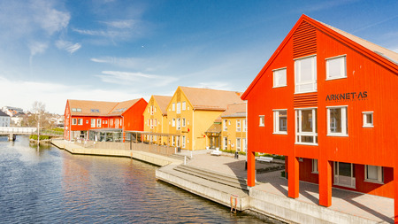 Kristiansand, Norway - June 4, 2015: Colorful wooden buildings over a narrow bay. Bay in Kristiansand. Sunny day in summerのeditorial素材