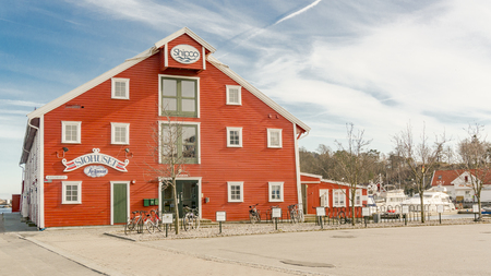 Kristiansand, Norway - June 4, 2015: Red wooden building restaurant. Colorful wooden buildings. Bay in Kristiansand.のeditorial素材