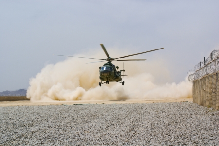 	helicopter landing in cloud of dustの写真素材