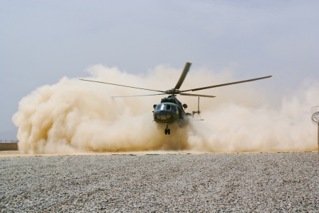 helicopter landing in cloud of dustの写真素材