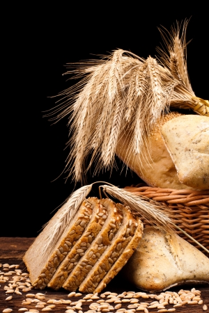 assortment of baked bread on wood table and black backgroundの写真素材