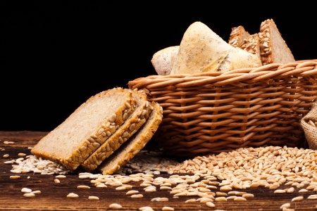 assortment of baked bread on wood table and black background