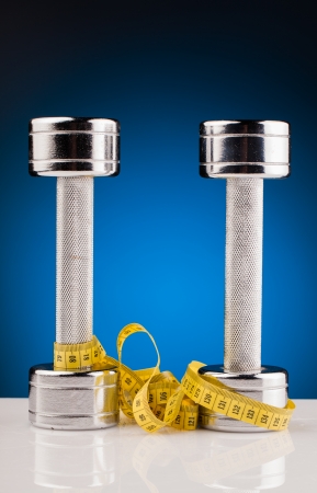 fitness dumbbells and measure tapeの写真素材