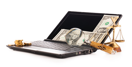 laptop computer keyboard money and magnifying glass の写真素材