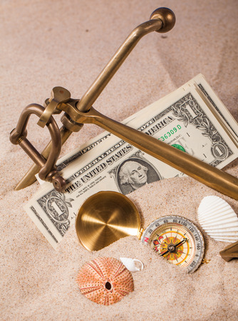 anchor money and compass on sandの写真素材