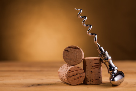 wine corkscrew and corks on wooden tableの写真素材