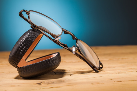 glasses on wooden table and blue backgroundの写真素材