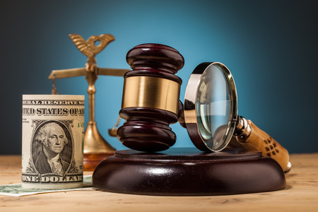 judge gavel and dollar money closeup on wooden table and blue backgroundの写真素材