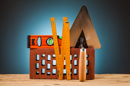brick and builder tools on wooden tableの写真素材